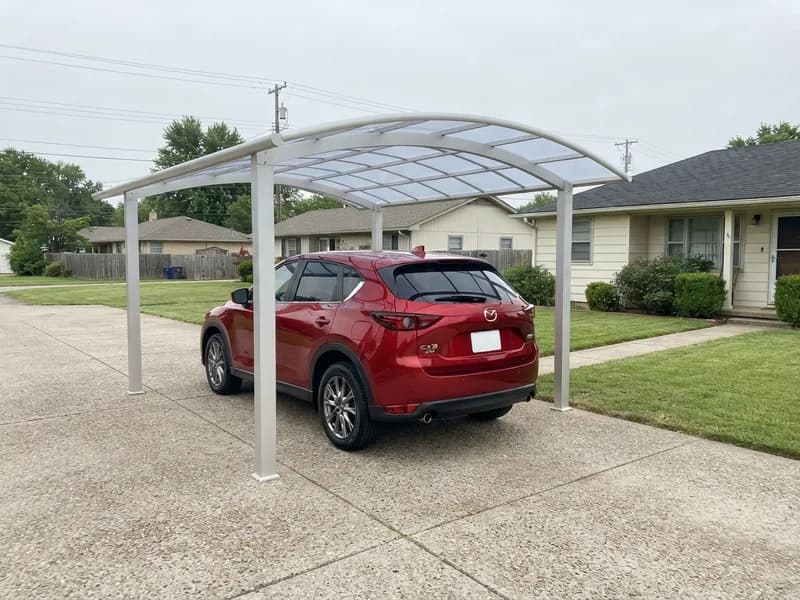 Freestanding aluminum carport with a polycarbonate roof and a 2022 Mazda CX-5 parked beneath on a suburban driveway