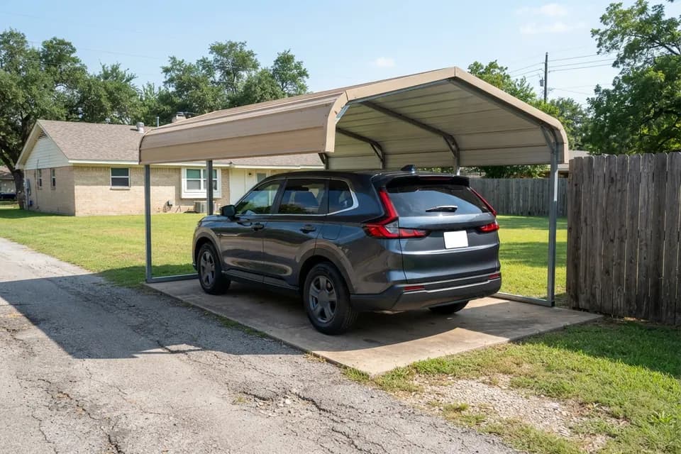 Detached steel carport at the rear of a residential lot beside an alley, sheltering a 2022 Honda CR-V