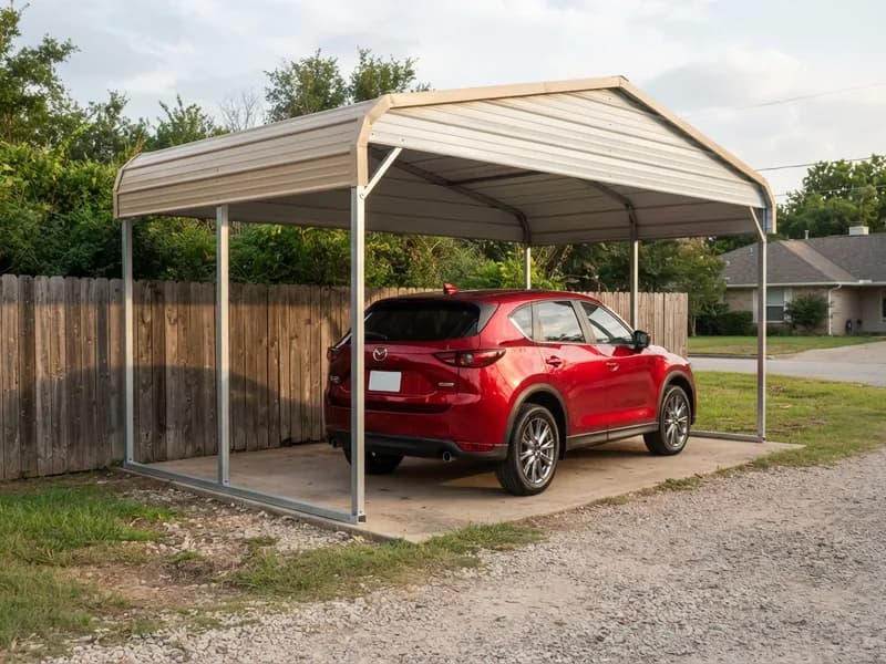 Detached steel carport beside a wood fence on a residential lot sheltering a 2022 Mazda CX-5